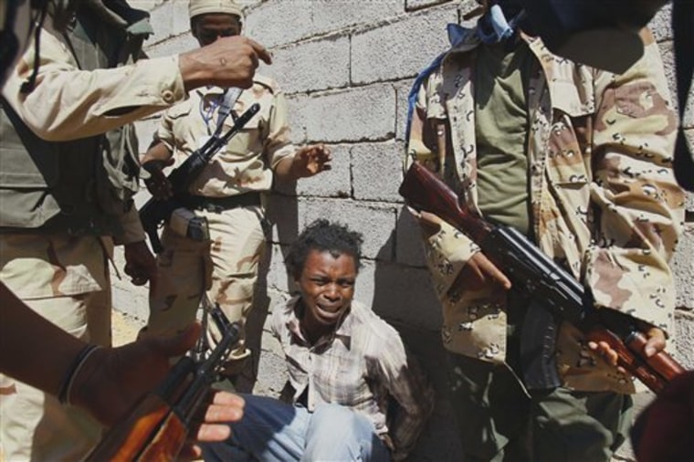 Libya fighters arrest a man from Nigeria, who they allege is a Gadhafi loyalist, in a village near Mahruga, on Saturday.